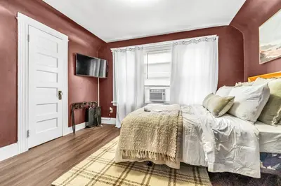 a bedroom with red walls and a bed and a window at Bedroom walking distance to Yale Bridgeport Hospital in Bridgeport