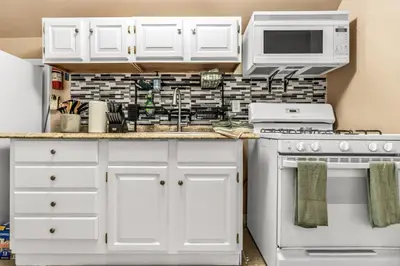 a kitchen with white cabinets and white appliances at Bedroom walking distance to Yale Bridgeport Hospital in Bridgeport