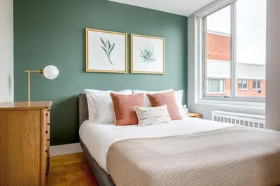 a bedroom with a bed and two pictures on the wall at Kips Bay 1BR w Doorman Elevator Gym NYC-478 in New York