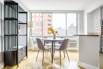 a dining room with a table and chairs and a window at Kips Bay 1BR w Doorman Elevator Gym NYC-478 in New York