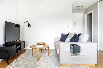 a living room with a white couch and a tv at Kips Bay 1BR w Doorman Elevator Gym NYC-478 in New York