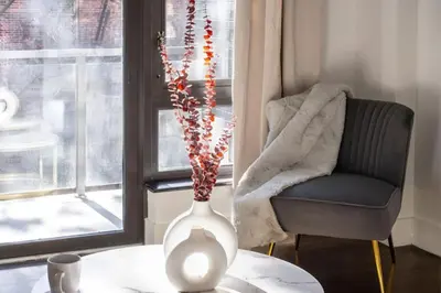 a white vase sitting on a table next to a chair at Large Upper East Side 1BD Elevator Rooftop in New York