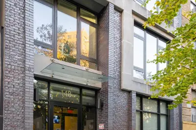 a brick building with a store front with windows at Large Upper East Side 1BD Elevator Rooftop in New York