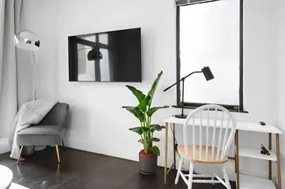 a living room with a desk and a chair and a plant at Large Upper East Side 1BD Elevator Rooftop in New York