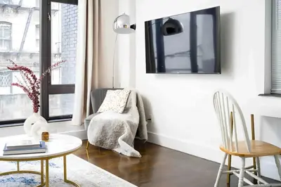 a living room with a chair and a table at Large Upper East Side 1BD Elevator Rooftop in New York