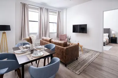 a living room with a couch and a table and chairs at Chic 1BD with Rooftop W/D in Unit Downtown in New York