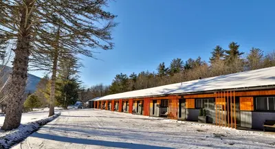 a building in the snow next to a tree at Matterhorns Hunter Lodge in Hunter