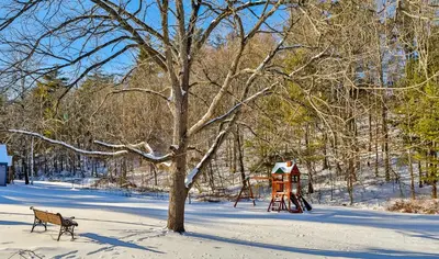 a park in the snow with a bench and a playground at Matterhorns Hunter Lodge in Hunter