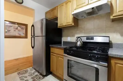 a kitchen with a stove and a refrigerator at 2Bed Bliss by Central Park North in New York