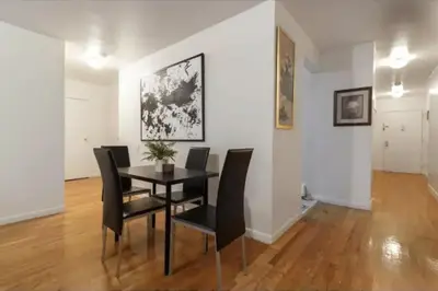 a dining room with a black table and chairs at 2Bed Bliss by Central Park North in New York