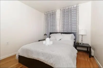 a bedroom with a bed with a candle on it at 2Bed Bliss by Central Park North in New York