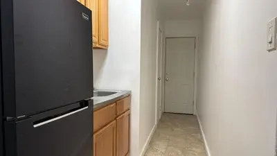 a kitchen with a black refrigerator and a sink at New York City Guest House 2 in New York