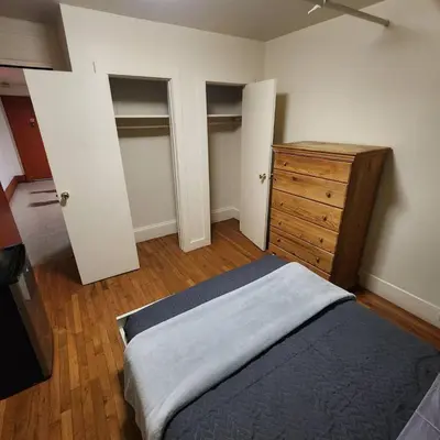 a bedroom with a bed and a wooden dresser at New York City Guest House 2 in New York