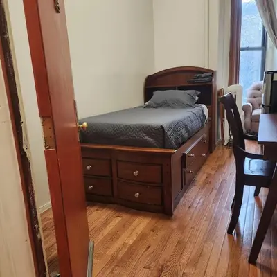 a bedroom with a bed and a wooden dresser at New York City Guest House 2 in New York
