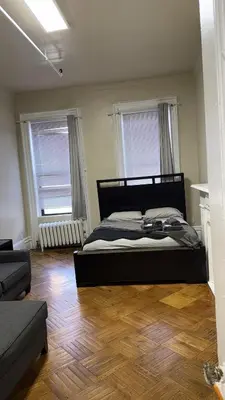 a bedroom with a large bed and two windows at New York City Guest House 2 in New York