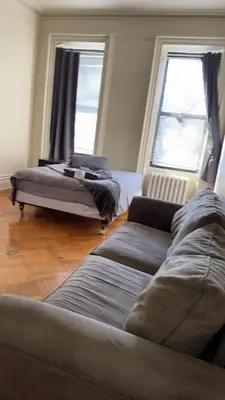 a living room with a couch and a bed at New York City Guest House 2 in New York