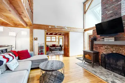a living room with a fireplace and a tv at Whistling Peak in Wilmington