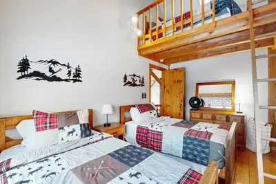 a bedroom with two beds and a staircase at Whistling Peak in Wilmington