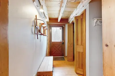 a hallway with a bench and a wooden door at Whistling Peak in Wilmington