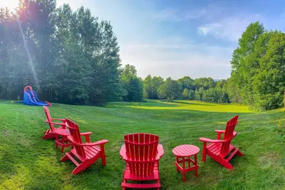 a group of red chairs and tables in a field at Whistling Peak in Wilmington