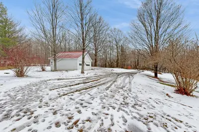 a snow covered road leading to a small white building at Whistling Peak in Wilmington