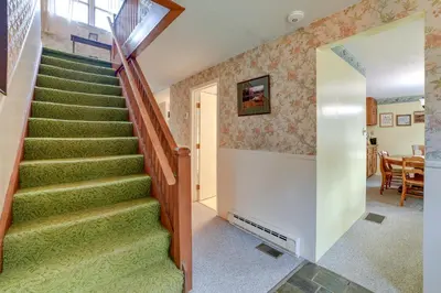 a winding staircase in a home with green carpeting at Fire Pit and On-Site Pond Wooded Walton Home! in Walton