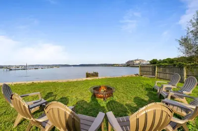 a group of chairs and a fire pit next to the water at Piermont Waterfront Villa! in Piermont