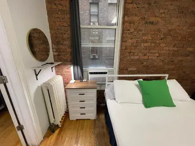 a small bedroom with a bed and a window at Nest 1 bedroom Aparthotel with kitchenette in New York