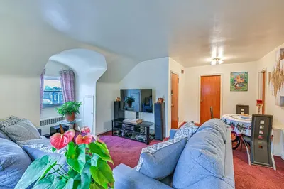 a living room with a blue couch and a table at Mount Vernon Getaway - 4 Mi to the Bronx Zoo! in New Rochelle