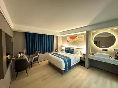 a hotel room with a bed and a desk and a mirror at Ly New York Hotel in College Point