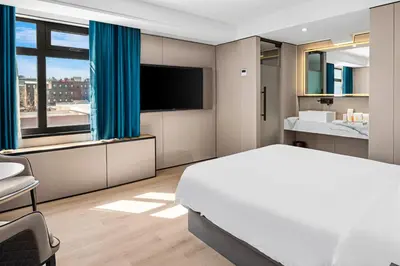 a bedroom with a large white bed and a television at Ly New York Hotel in College Point