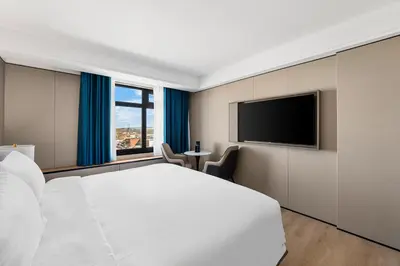 a bedroom with a white bed and a flat screen tv at Ly New York Hotel in College Point