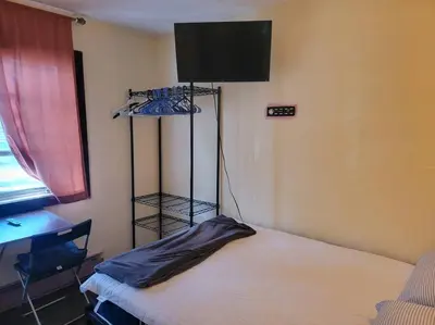 a room with a bed and a desk and a television at Rock Pad AirBnB in New Haven