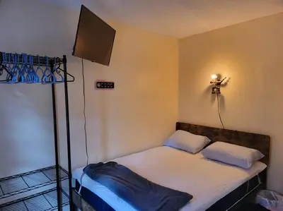 a bedroom with a bed with a tv on the wall at Rock Pad AirBnB in New Haven