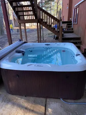 a jacuzzi tub sitting outside of a house at Open Concept & Stylish-HotTub-Sauna-Billiard-Poker-BBQ in East Stroudsburg
