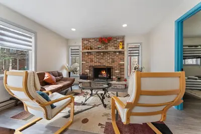 a living room with two chairs and a fireplace at Open Concept & Stylish-HotTub-Sauna-Billiard-Poker-BBQ in East Stroudsburg