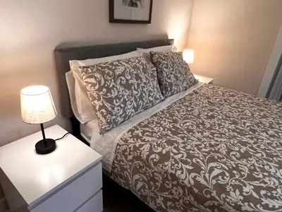 a bedroom with a bed and a lamp on a night stand at HOME Close to Yale New Haven Hospital in New Haven