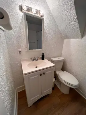 a bathroom with a toilet and a sink and a mirror at HOME Close to Yale New Haven Hospital in New Haven