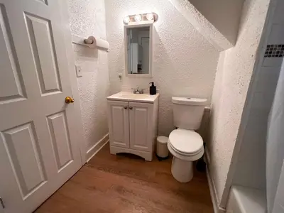 a bathroom with a toilet and a sink and a mirror at HOME Close to Yale New Haven Hospital in New Haven