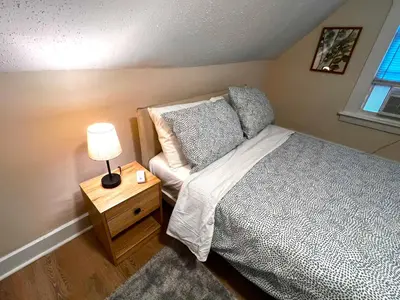 a bedroom with a bed and a table with a lamp at HOME Close to Yale New Haven Hospital in New Haven