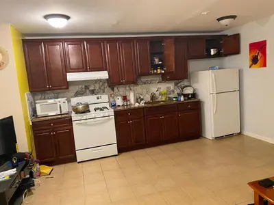 a kitchen with wooden cabinets and a white refrigerator at The Green Place of Newark in Newark