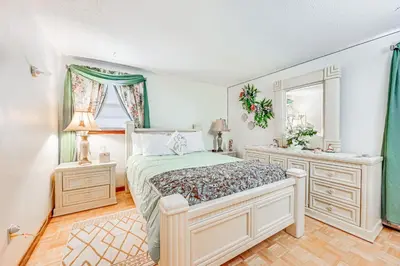 a bedroom with a large bed and a window at Vintage Windsor Home Private Yard and Covered Deck in Windsor