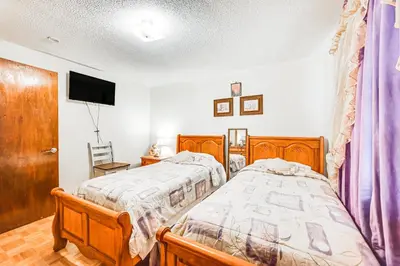 a bedroom with two beds and a flat screen tv at Vintage Windsor Home Private Yard and Covered Deck in Windsor