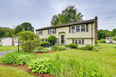 a yellow house with a yard at Vintage Windsor Home Private Yard and Covered Deck in Windsor