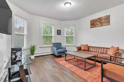 a living room with a couch and a table at Frog Hollow Red Door Loft in Hartford