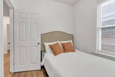 a bedroom with a white bed with two pillows at Frog Hollow Red Door Loft in Hartford