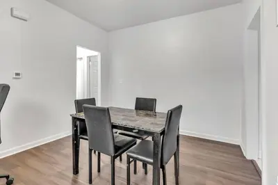 a dining room table and chairs in a white room at Frog Hollow Red Door Loft in Hartford