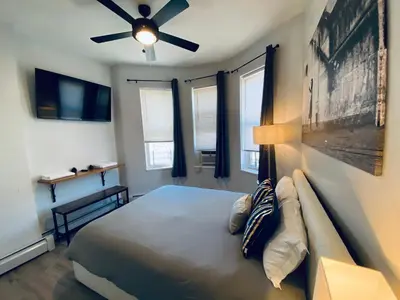 a bedroom with a bed and a ceiling fan at NYC Oasis in Mott Haven