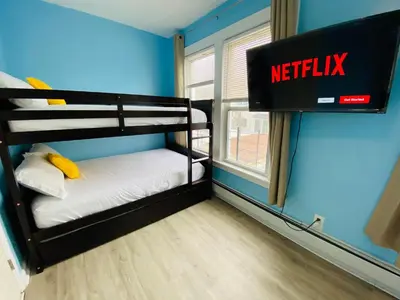 a small room with two bunk beds and a netflix sign at NYC Oasis in Mott Haven