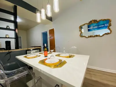 a white kitchen with a table with glasses and a mirror at NYC Oasis in Mott Haven